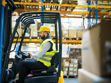 Workhouse worker driving forklift