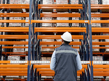 Man standing in front of Orange Racking in a warehouse