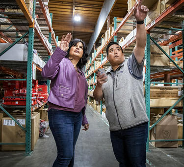 Two warehouse employees check inventory together