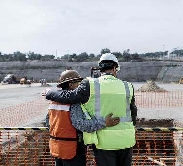 Two employees congratulate each other at a groudbreaking