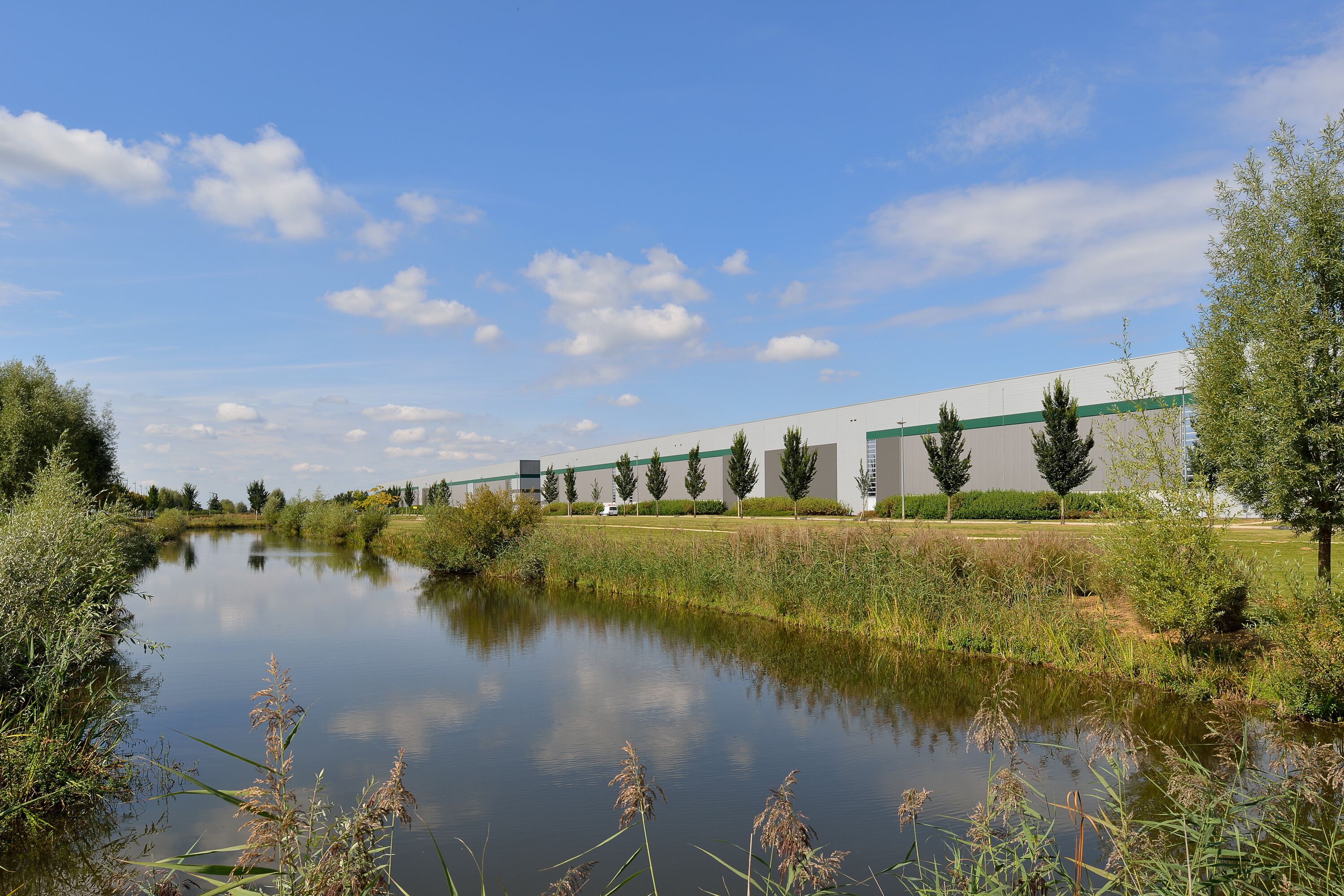 Un entrepôt avec des arbres et une rivière en arrière-plan Un entrepôt avec des arbres et une rivière en arrière-plan