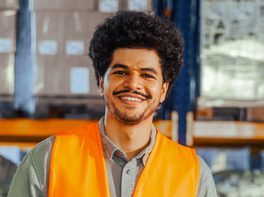 Homme souriant dans un entrepôt Homme souriant dans un entrepôt